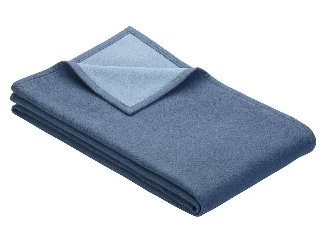 Folded blanket in blue and light blue on reverse side