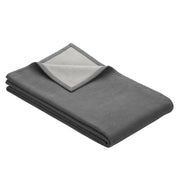 Folded blanket in grey with light grey on reverse side
