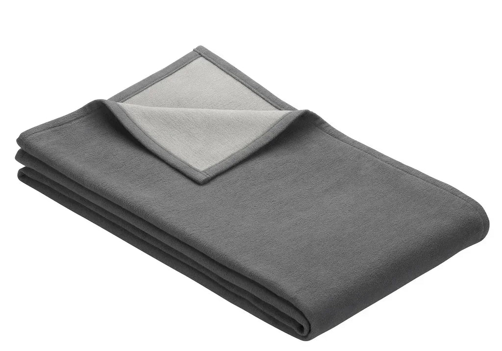 Folded blanket in grey with light grey on reverse side