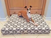 greyhound dog laying on organic orthopedic dog bed in white and brown picasso print